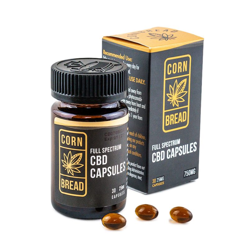 A bottle of Cornbread CBD Capsules beside its box, with three capsules close to it.
