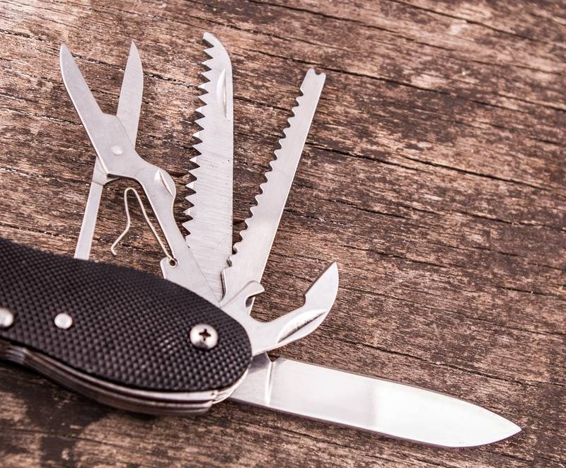 survival knife with it's scissors, saw, can opener, and knife blade open.