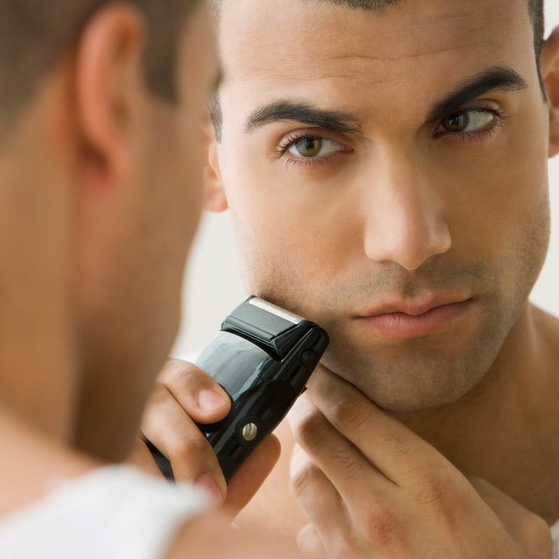 A man shaving in the mirror.