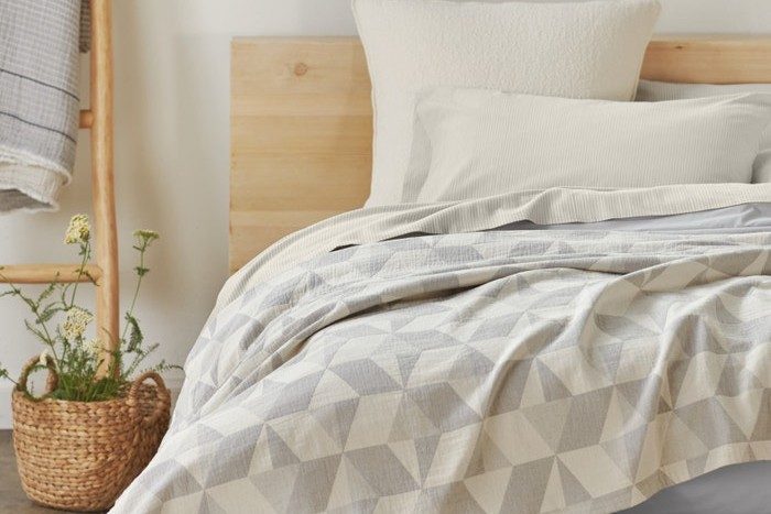 Unmade bed with Coyuchi Pismo Organic Blanket.