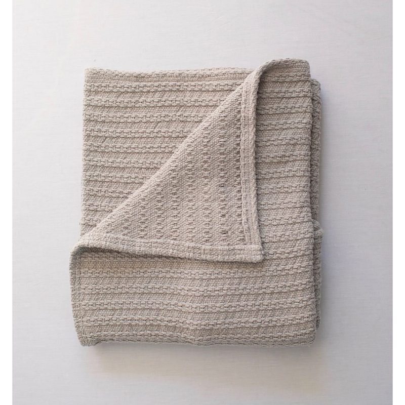Folded Evangeline Cotton Cable Knit Throw on a gray background.
