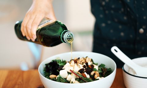 Pouring olive oil in a salad