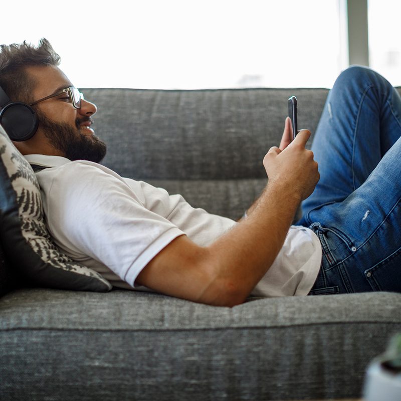 man reading audible books on the couch.