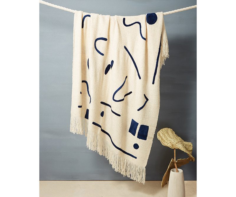 Minna Abstract Throw Indigo hanging on a clothesline.