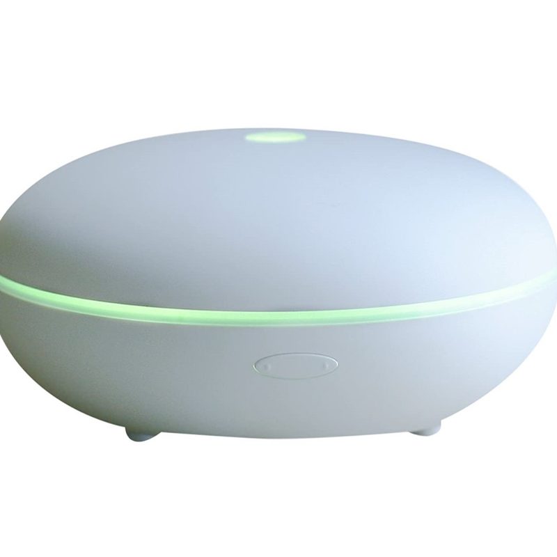 A lit up Smiley Daisy Essential Oil Diffuser on white background.
