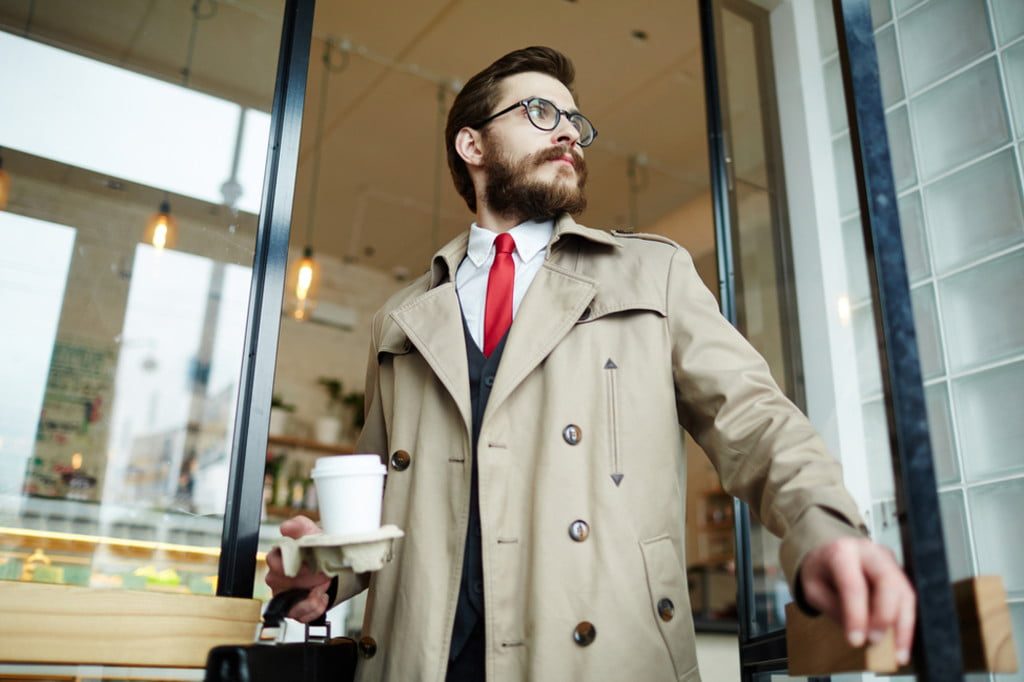 man in trench coat leaving coffee shop