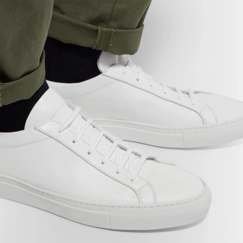 Common Projects Original Achilles Leather Sneakers paired with dark green pants and black socks.