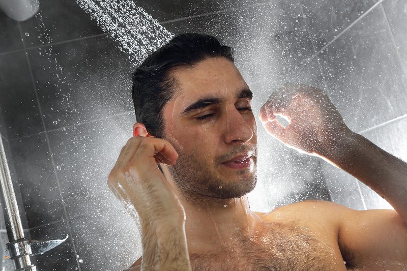 Man taking a shower washing his hair.