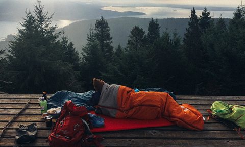 what is a microadventure man sleeping on mountain by trees against sky
