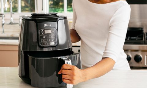Woman using Ninja air fryer.