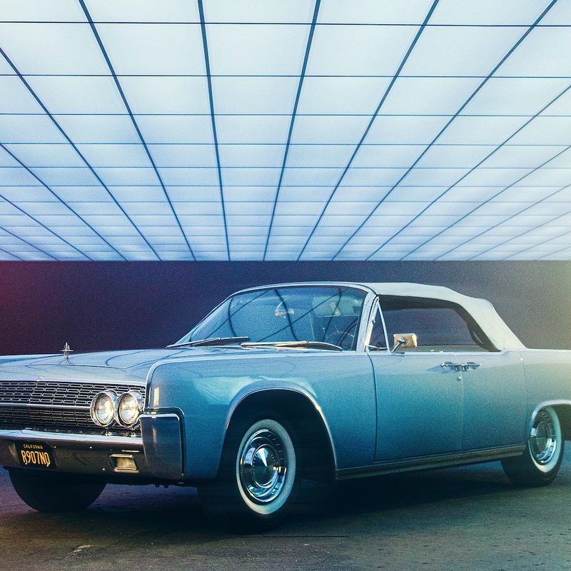 Blue classic American car parked sideways.