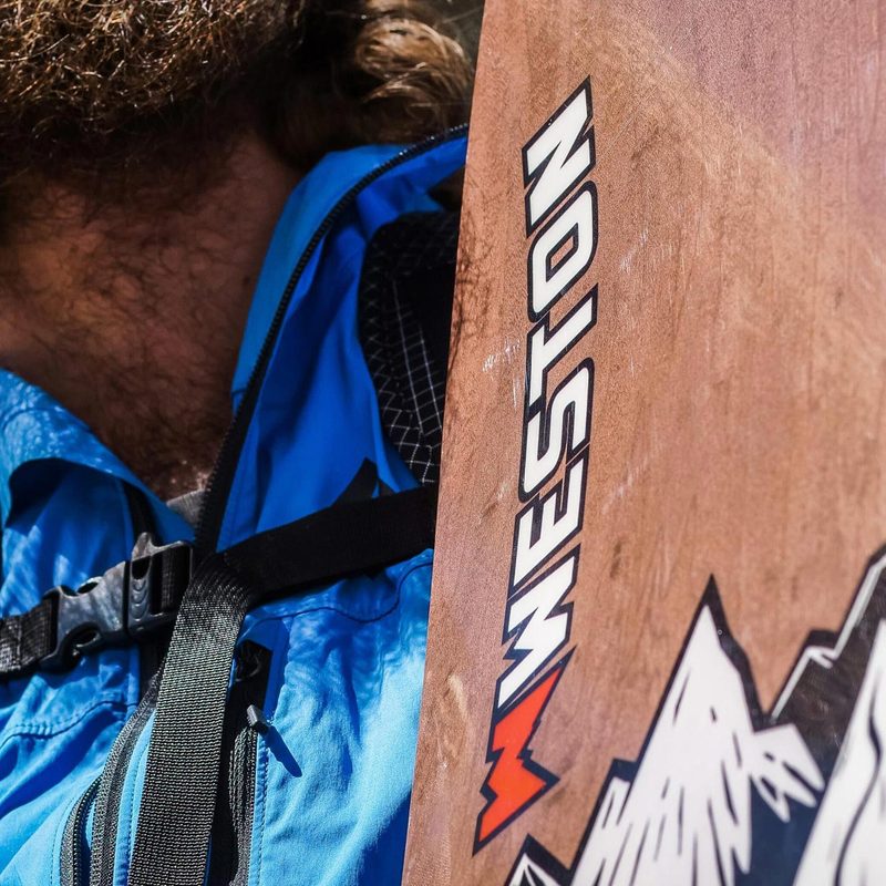 Closeup of snowboarder holding Weston Backcountry Backwoods Snowboard.