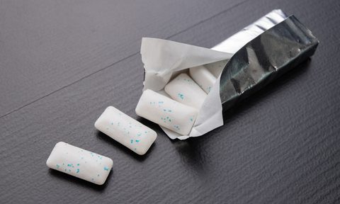 best gum brands chewing on the table  mint refreshing tablet in a silver package dark background