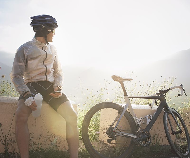 Cyclist taking break, sitting near bike