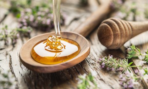 best honey brands herbal pouring into the wooden spoon