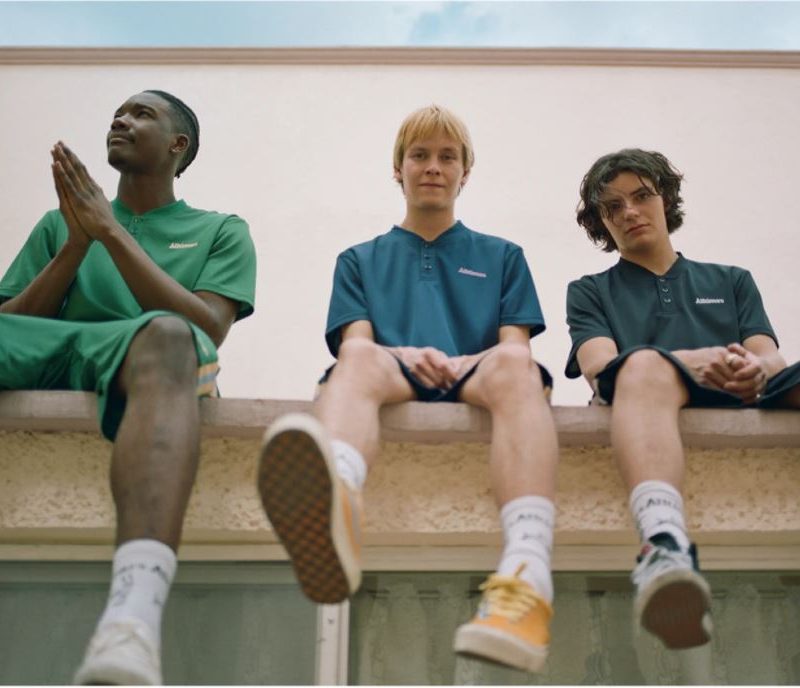 Three guys sitting on ledge