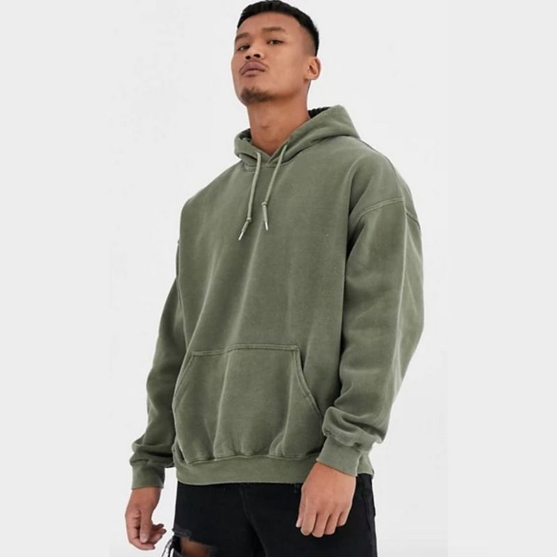 A male model wearing a green Asos Reclaimed Vintage-Inspired Oversized Hoodie.