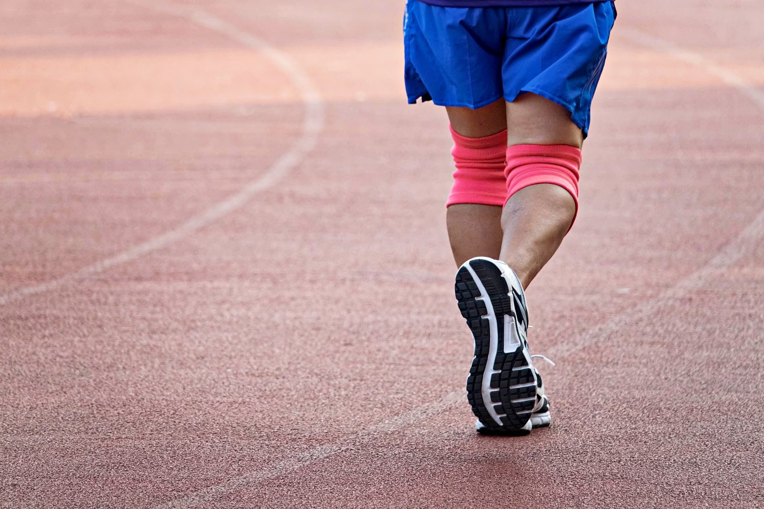 Man running with knee braces.