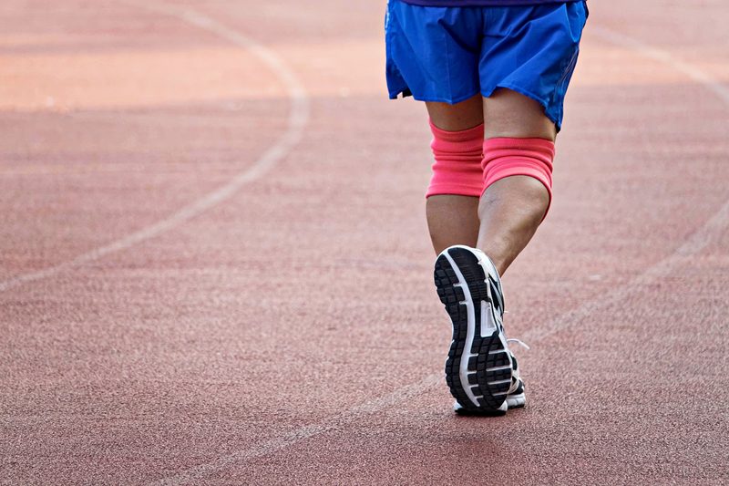 Man running with knee braces.