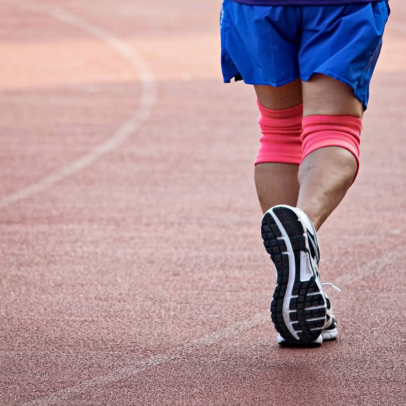 Man running with knee braces.