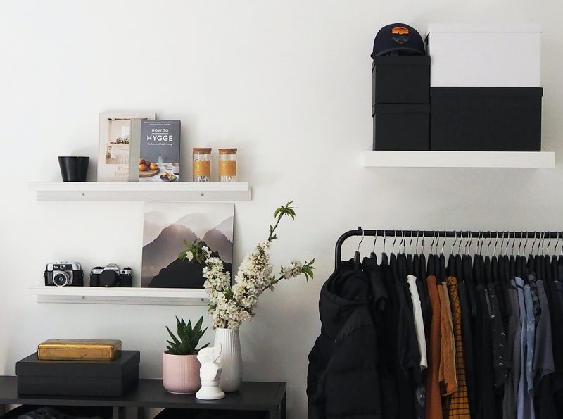 Bedroom with mens clothing rack and open storage shelves