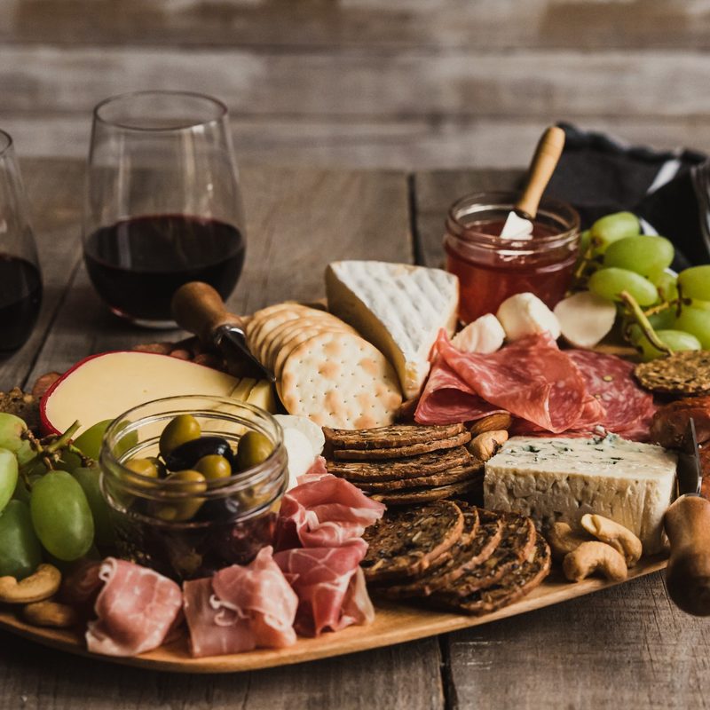 Charcuterie board and glasses of wine on a wooden table