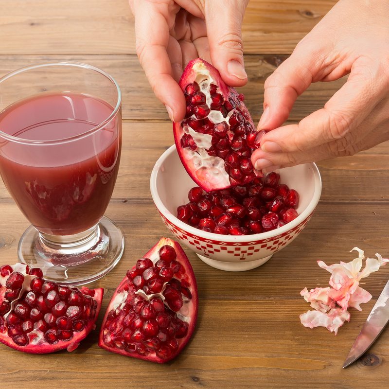 Person removing pomegranate seeds from the fruit