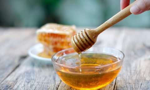 Honey dipper and honeycomb on a table