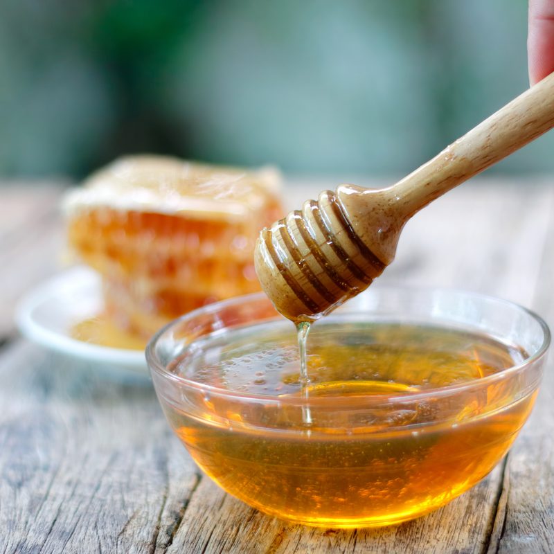Honey dipper and honeycomb on a table