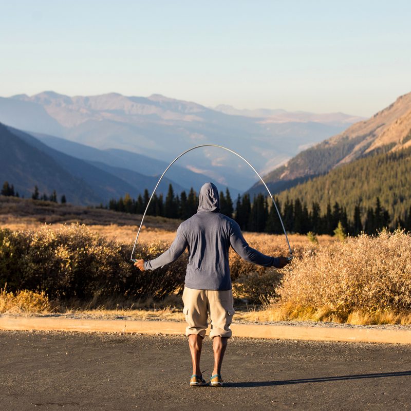 Man jumping rope outside in a hoodie