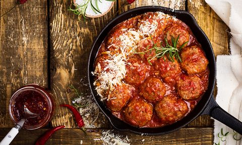 best frozen meatball brands meatballs in sour tomato sauce with grated parmesan cheese on top