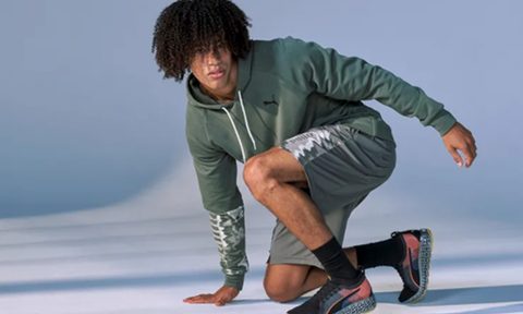A man posing in Puma clothes and shoes.