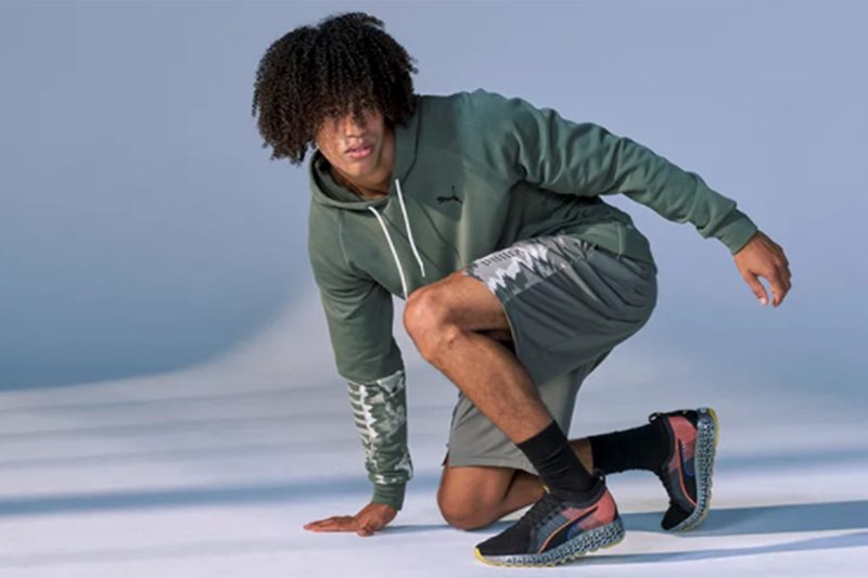 A man posing in Puma clothes and shoes.