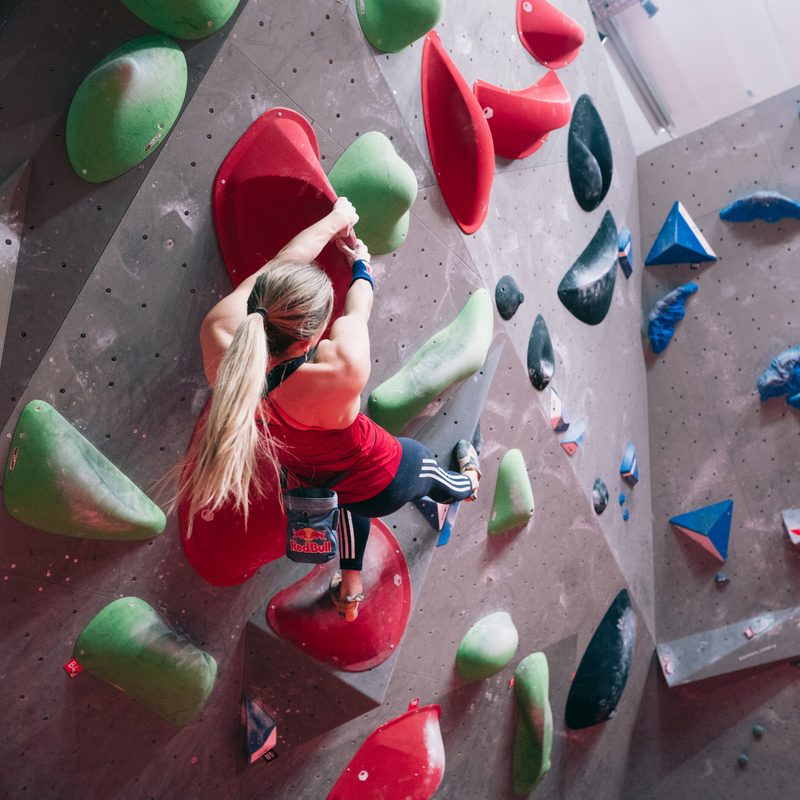 Woman doing the climbing wall inside