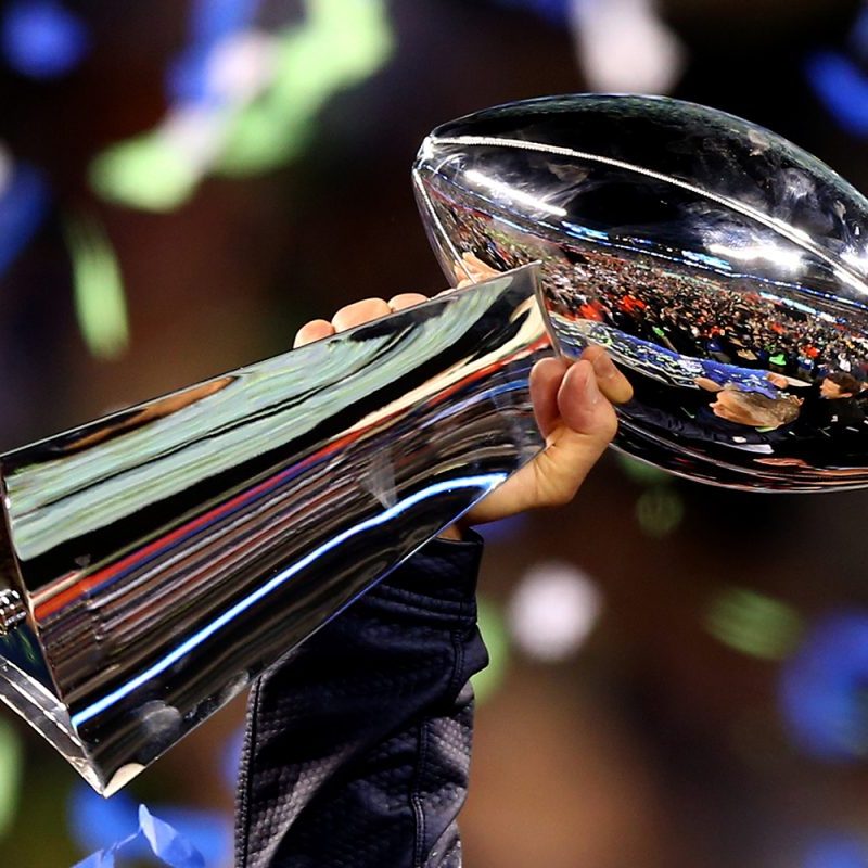 Person holding up the Super Bowl trophy.