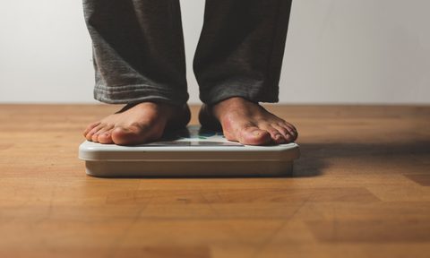 the best scales low section of man standing on weight scale over hardwood floor at home