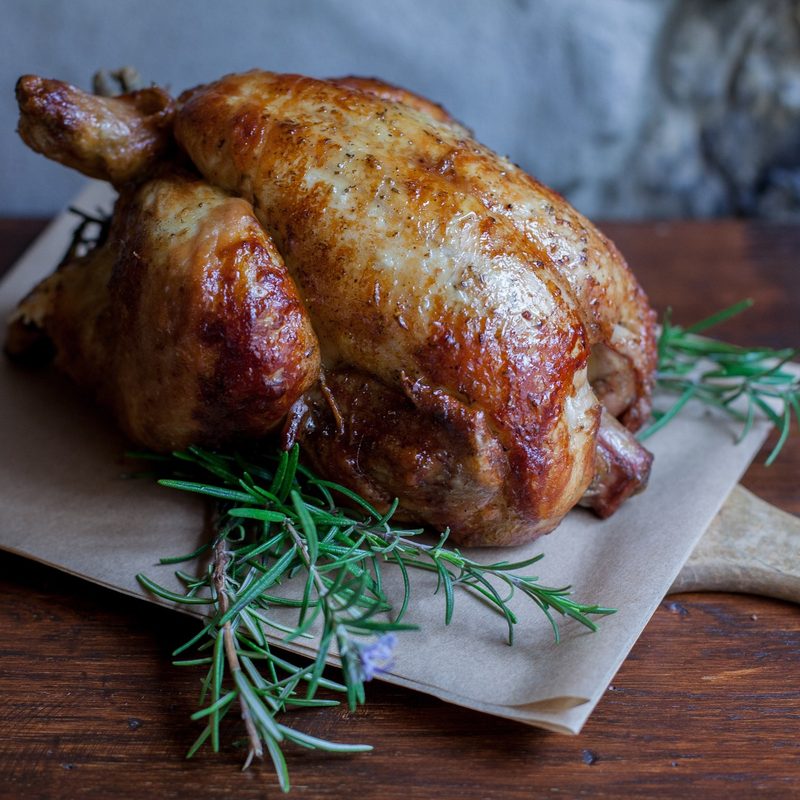 Roasted chicken on a cutting board at the table