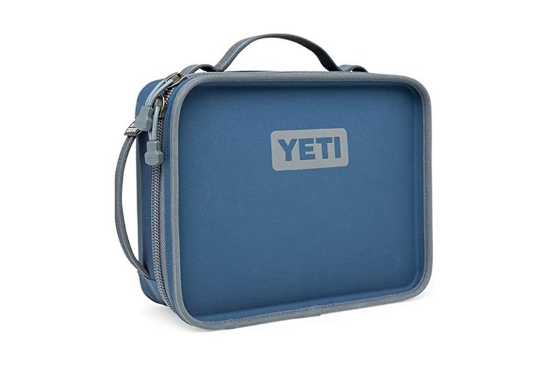 The YETI Daytrip Lunch Box features a impressive insulation and lightweight design, all in its blue and gray colors.