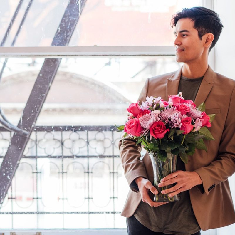 Man holding a bouquet of flowers.