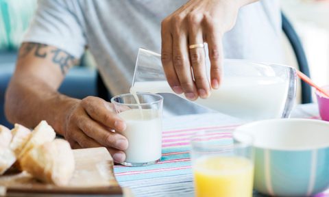 best oat milk brands midsection of man pouring in drinking glass at table
