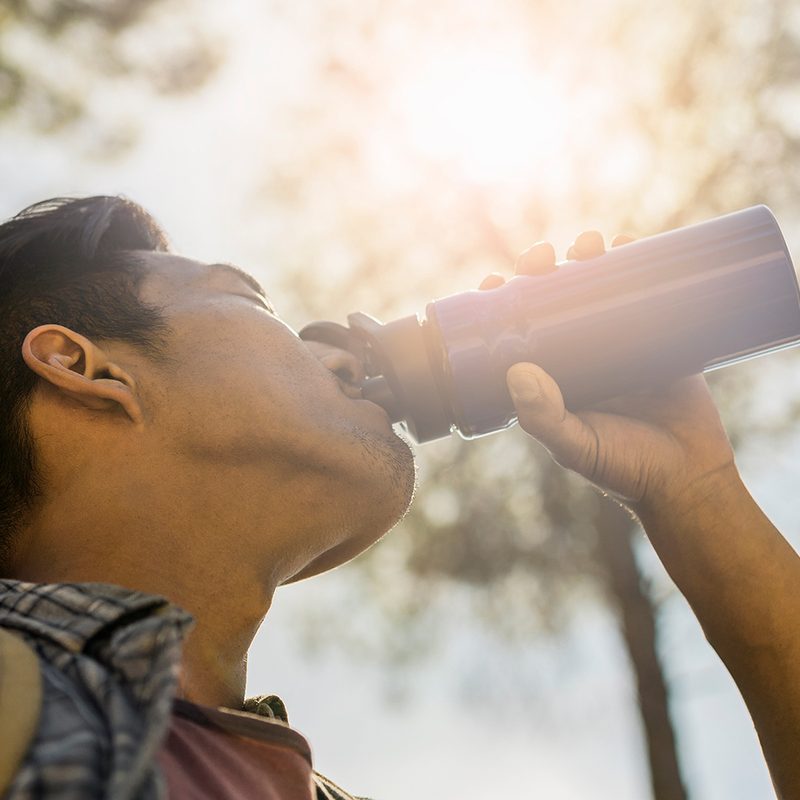man drinking from a water bottle. 