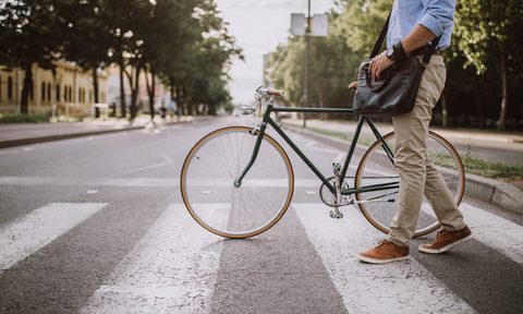 man walking with his bike on a pedestrian lane.