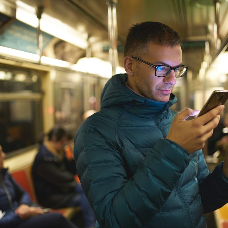 Man using his phone on the subway.