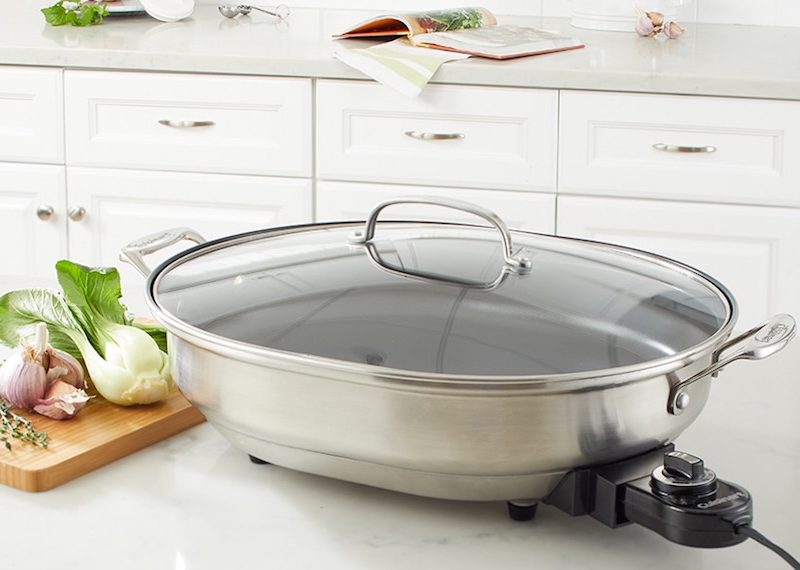 Stainless electric skillet on a kitchen countertop.