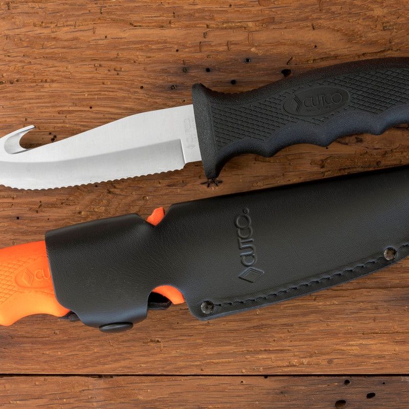 Cutco Gut Hook Hunting Knife and sheath on a wood table.