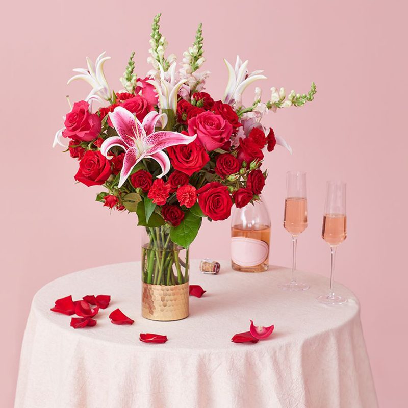 FTD roses on a table with wine.