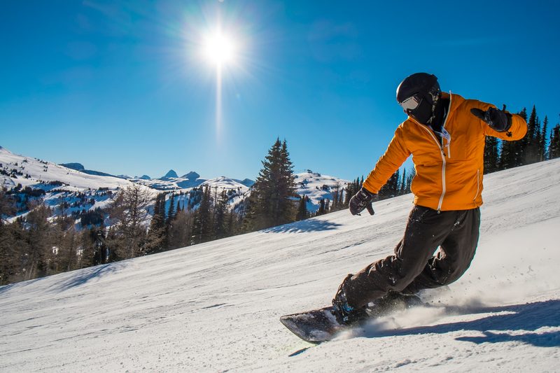 Snowboarder cranks turn on mountain slope