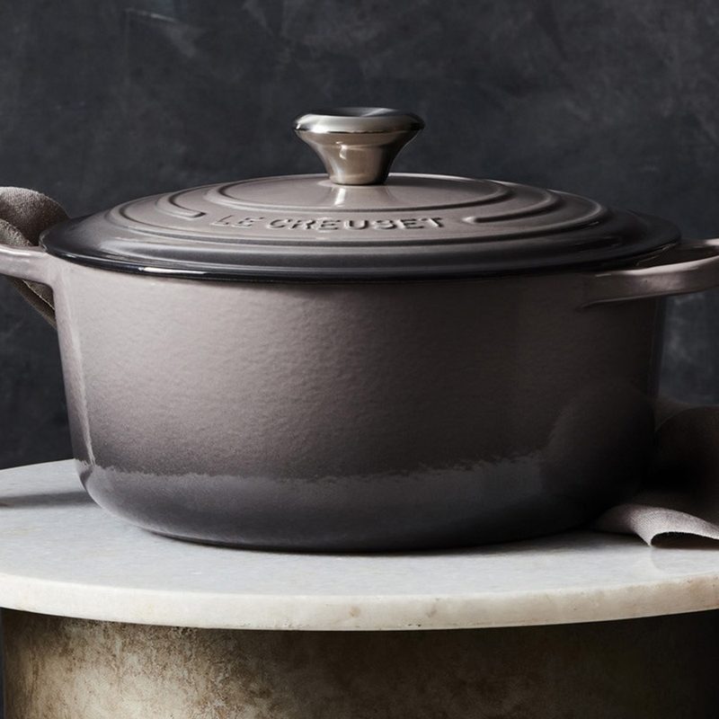Le Creuset kitchenware with towel wrapped through handle.