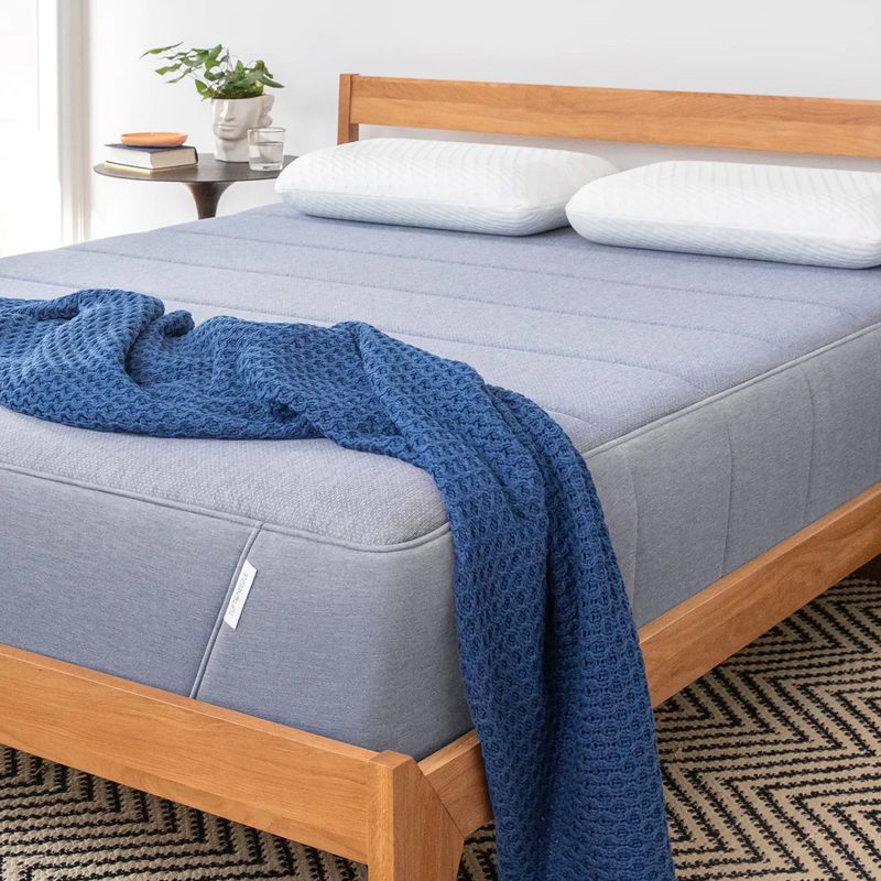 The Tuft & Needle Hybrid Mattress on a wooden bed frame.