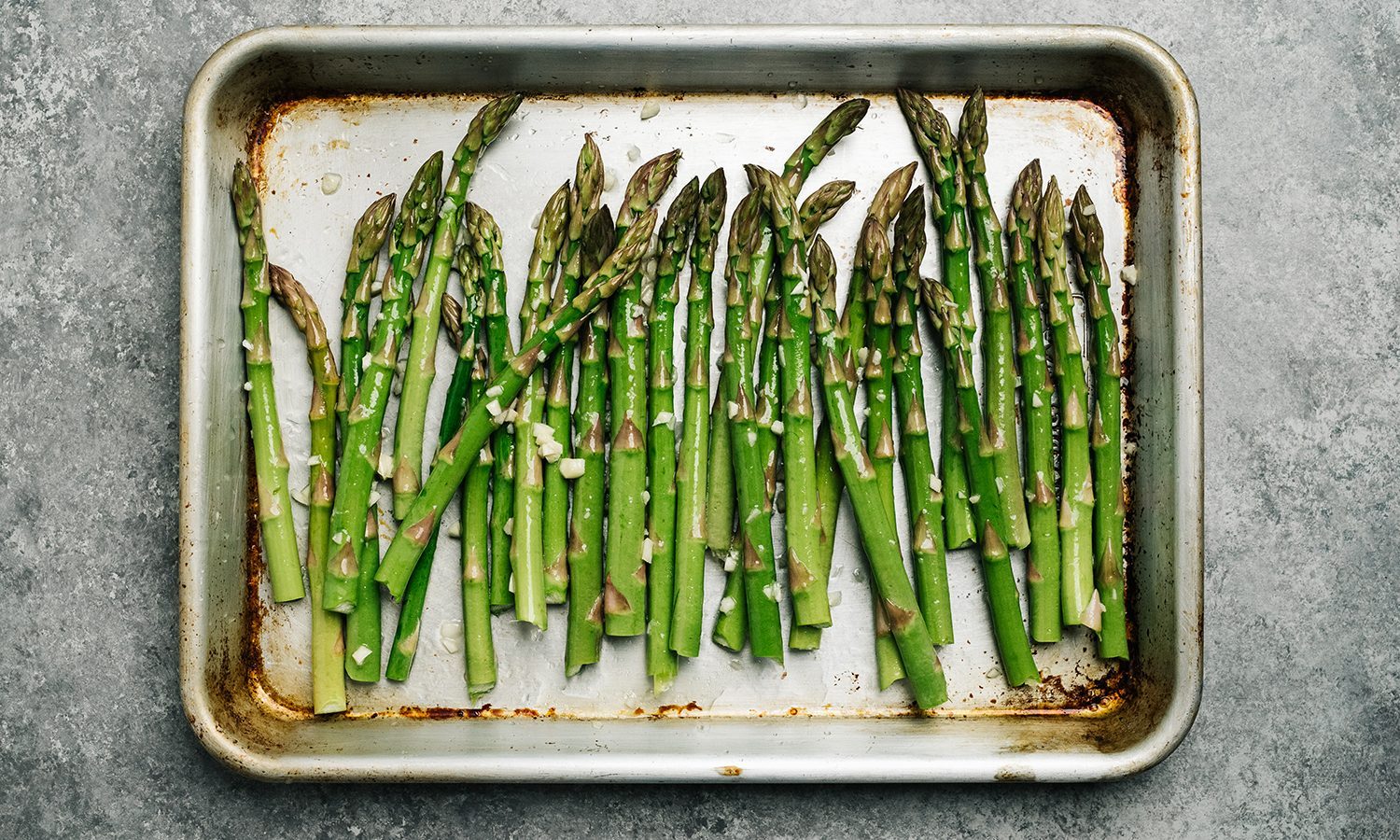 Oiled asparagus on a baking sheet